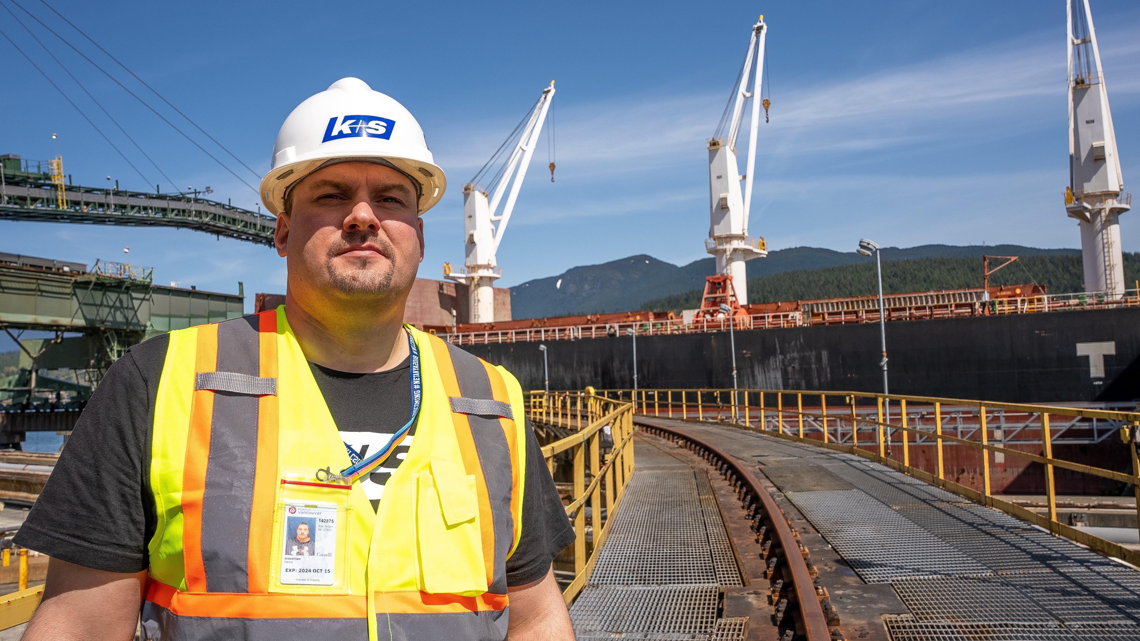 Ein Mann in Arbeitskleidung steht vor dem Hafen in Vancouver
