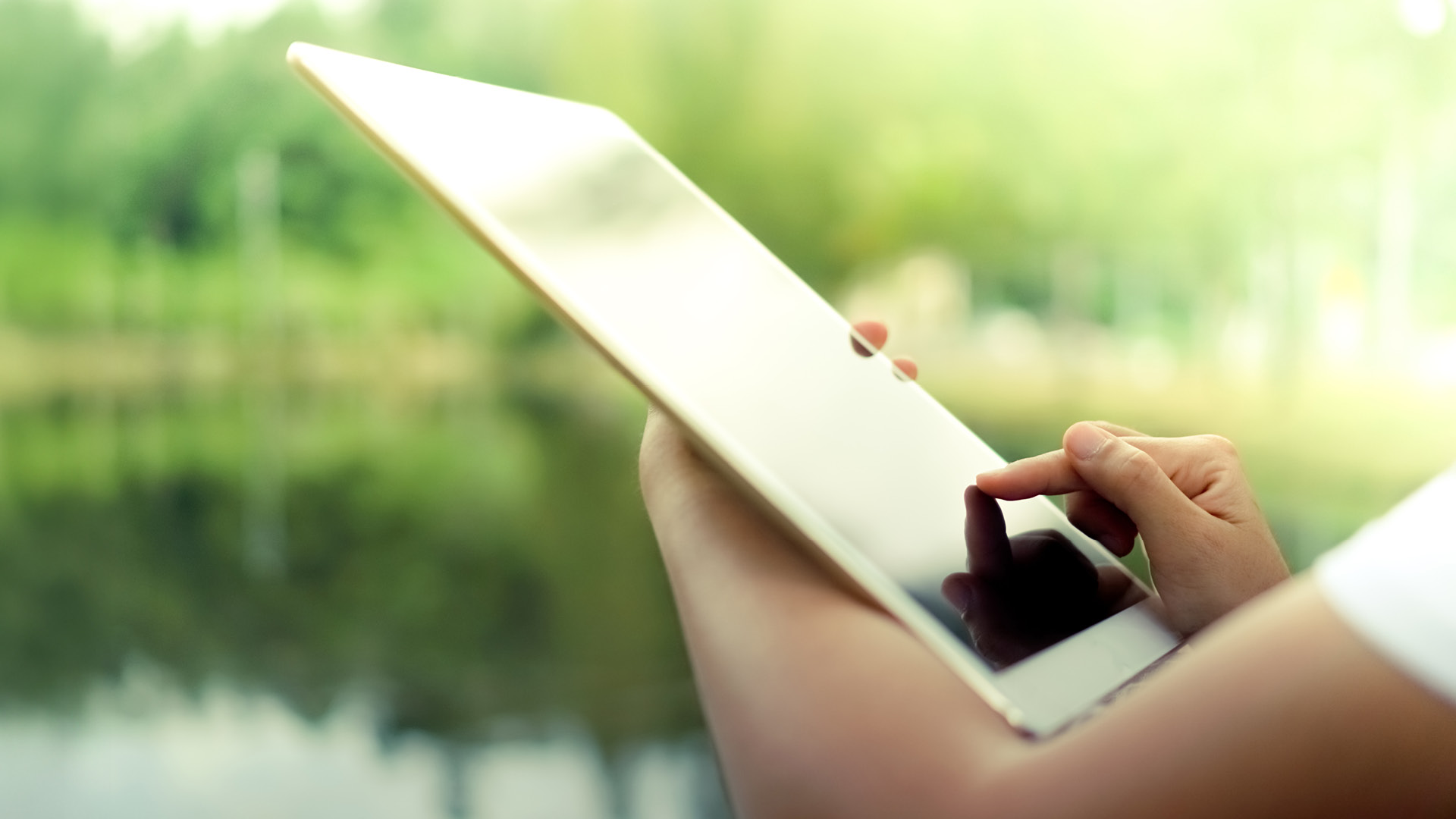 Auf der linken Bildseite ist das KALI Akademie Logo zu sehen. Auf der anderen Bildhälfte ist ein Tablet zu sehen, der Hintergrund ist eine grüner See.