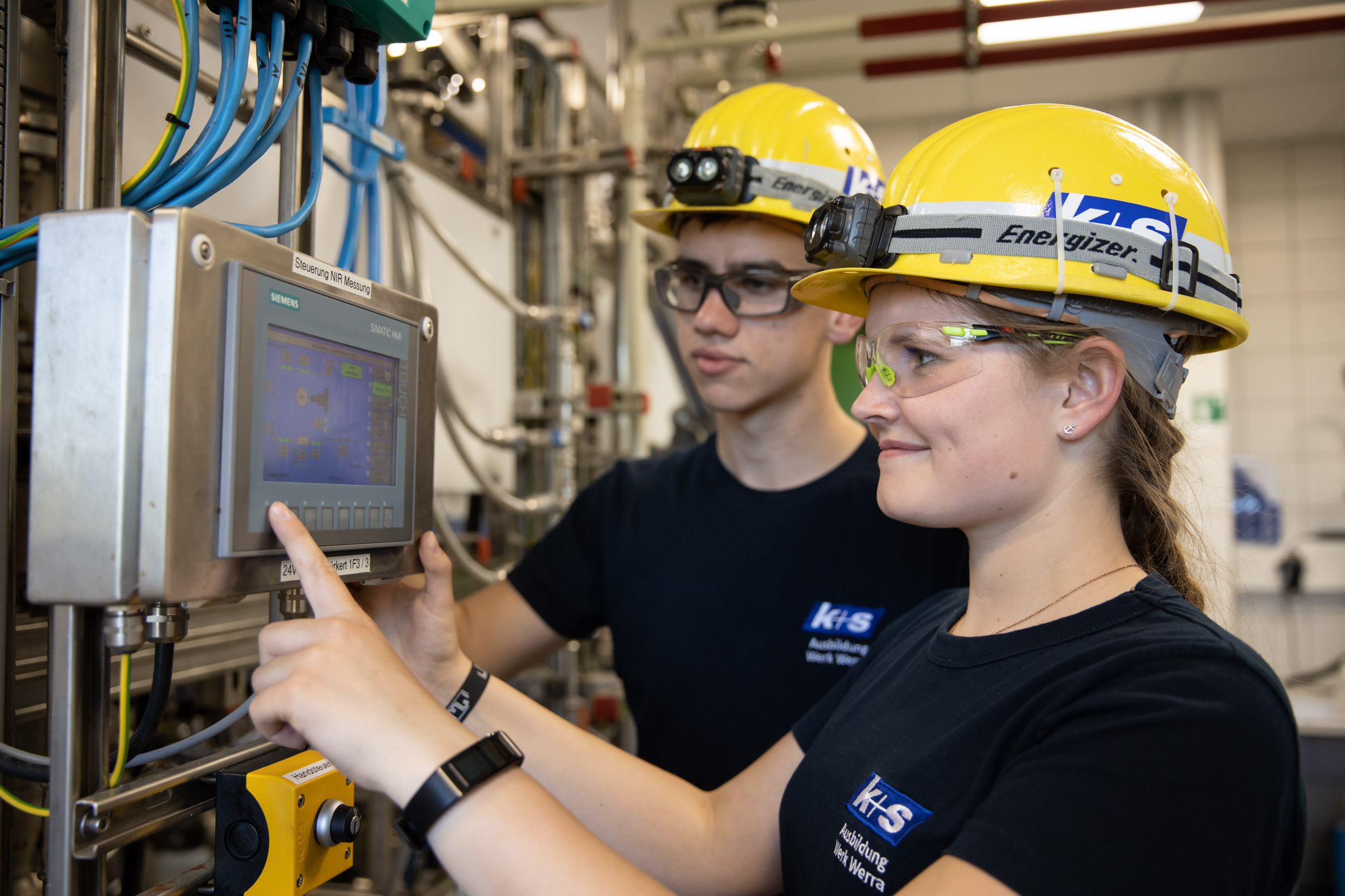 Chemikant:innen bedienen ein technisches Gerät