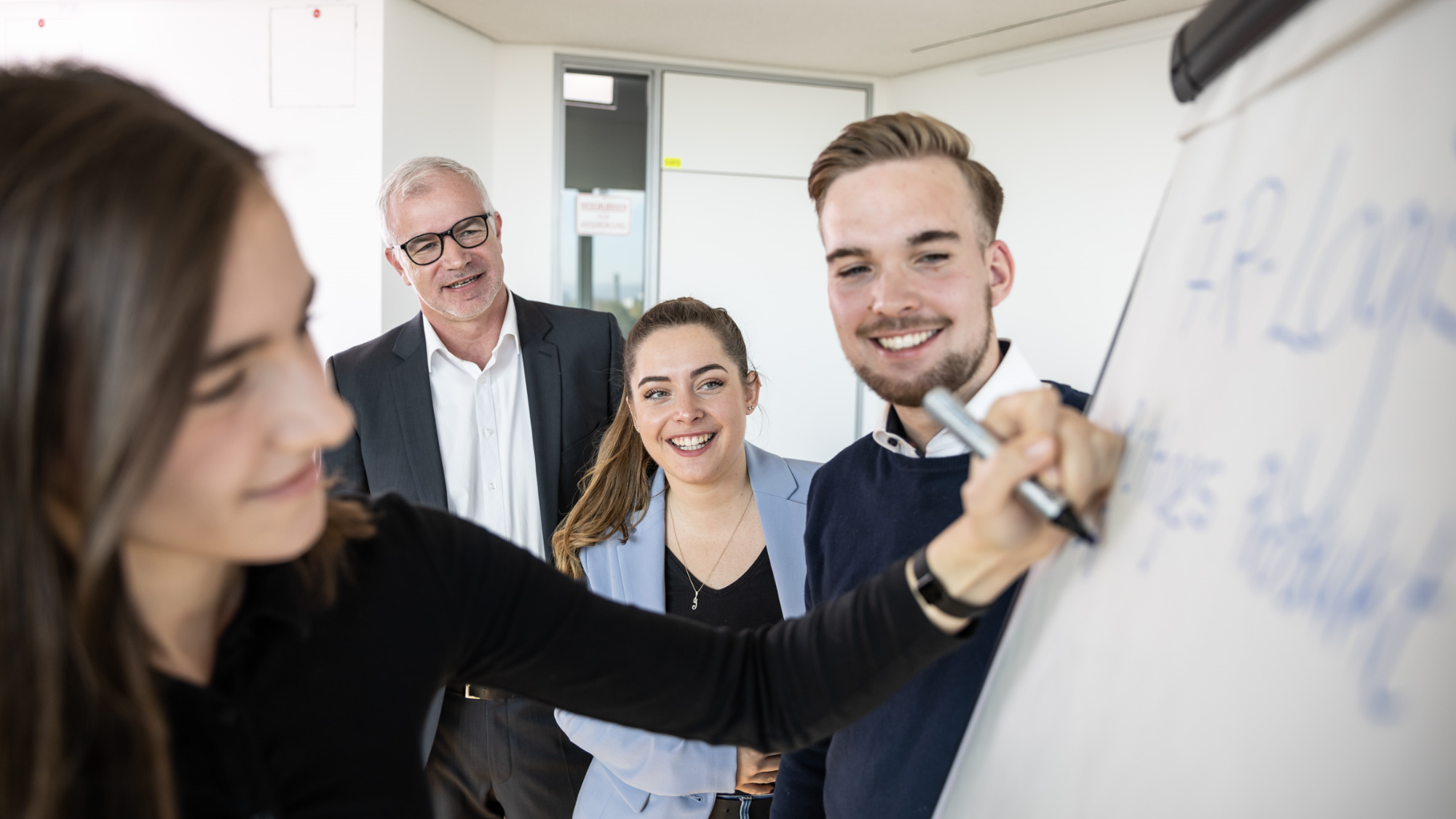 Studierende präsentieren gemeinsam Ideen an einem Flipchart