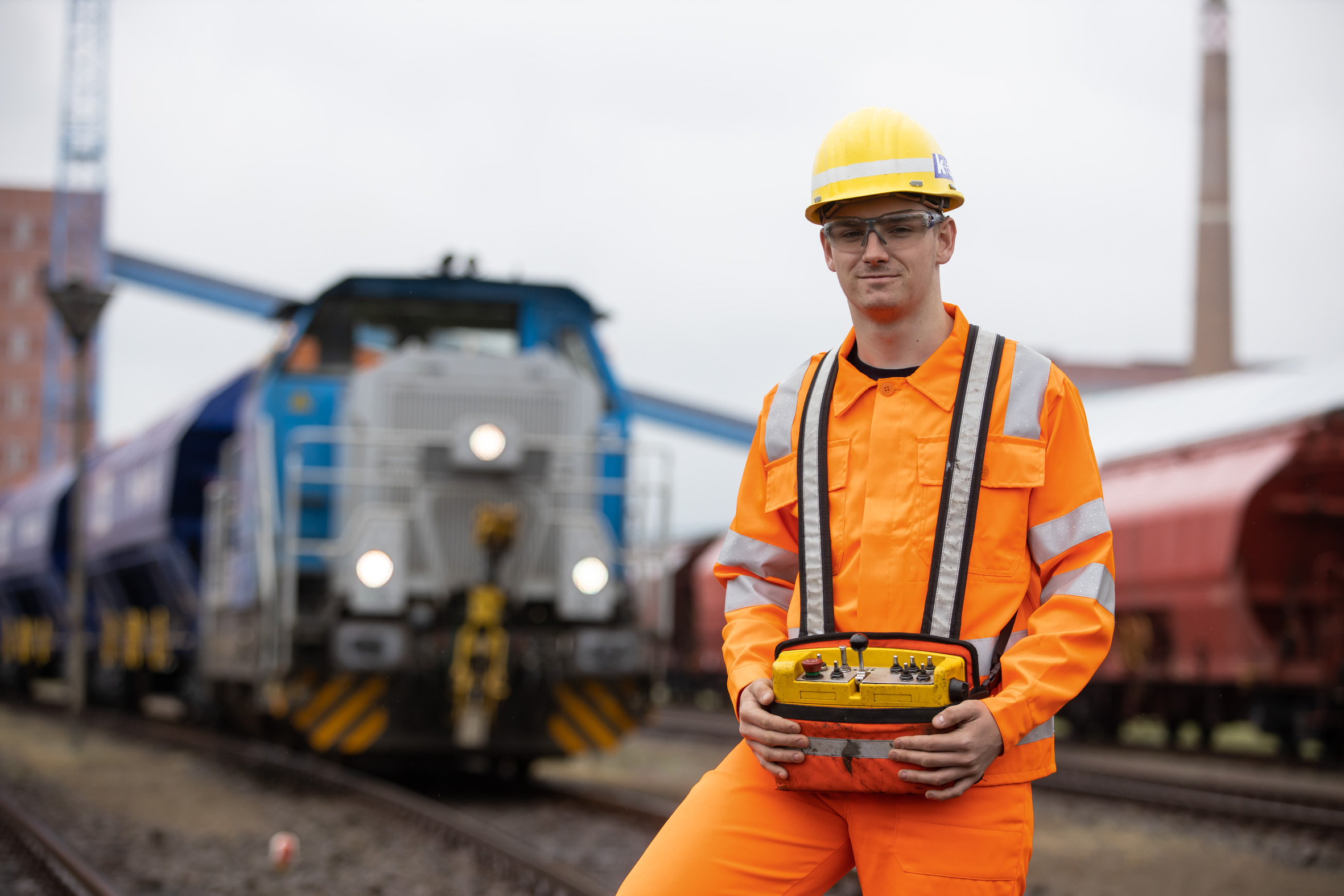 Eisenbahner im Betriebsdienst steht vor einer Lokomotive