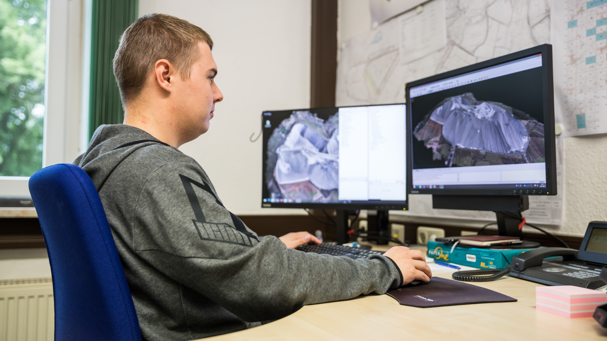 Dualer Student bei der Arbeit mit 3D-Geodaten am PC.