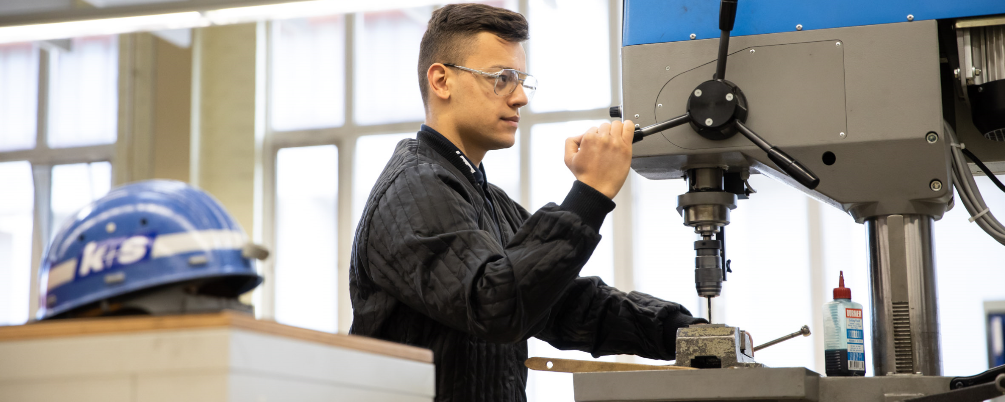 Azubi bedient eine Werkstattmaschine