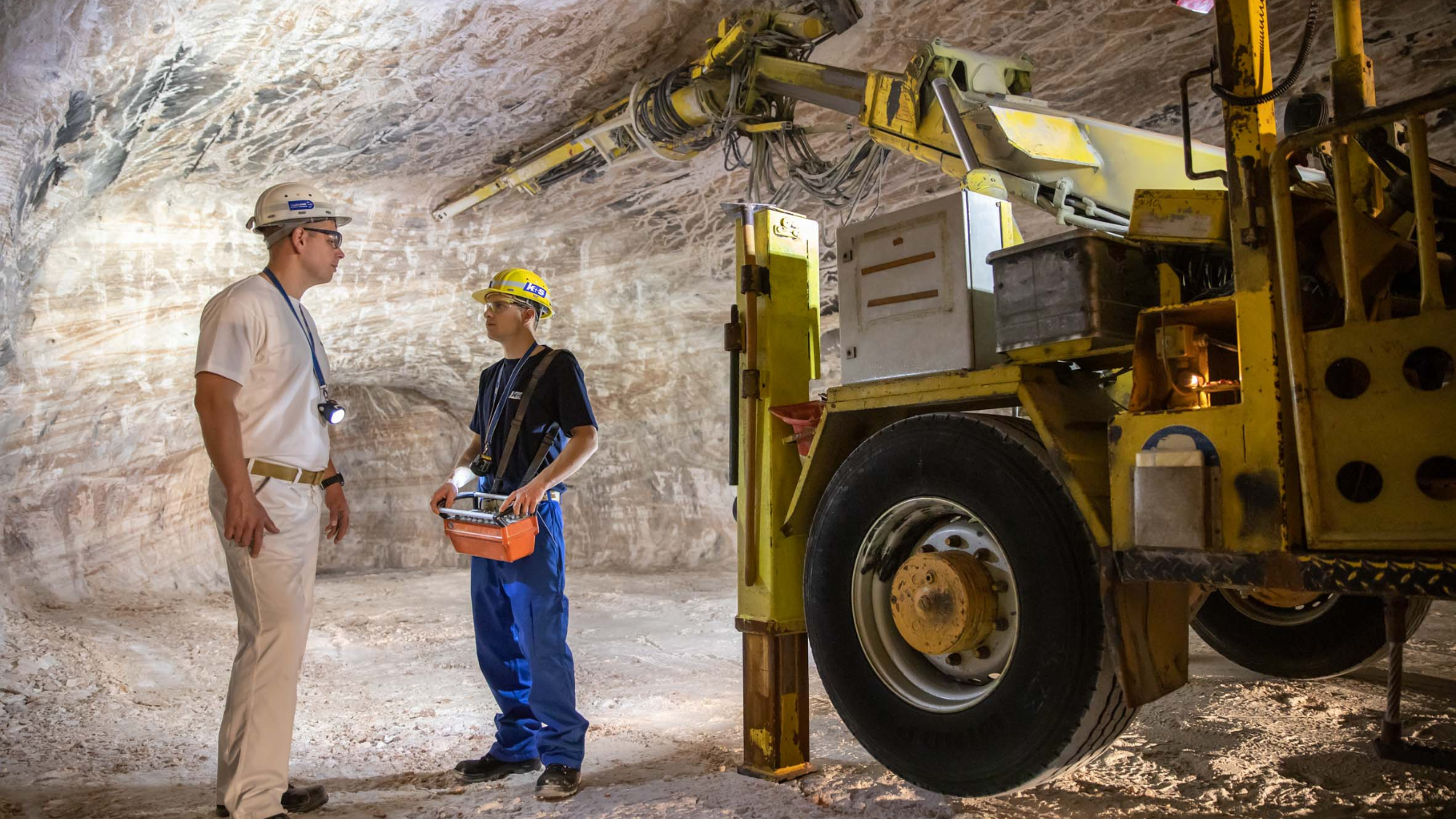 Mining technologists in front of machine underground 