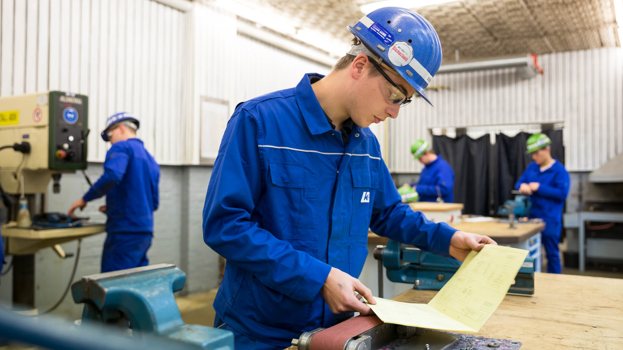 Industriemechaniker-Auszubildender prüft technische Zeichnung