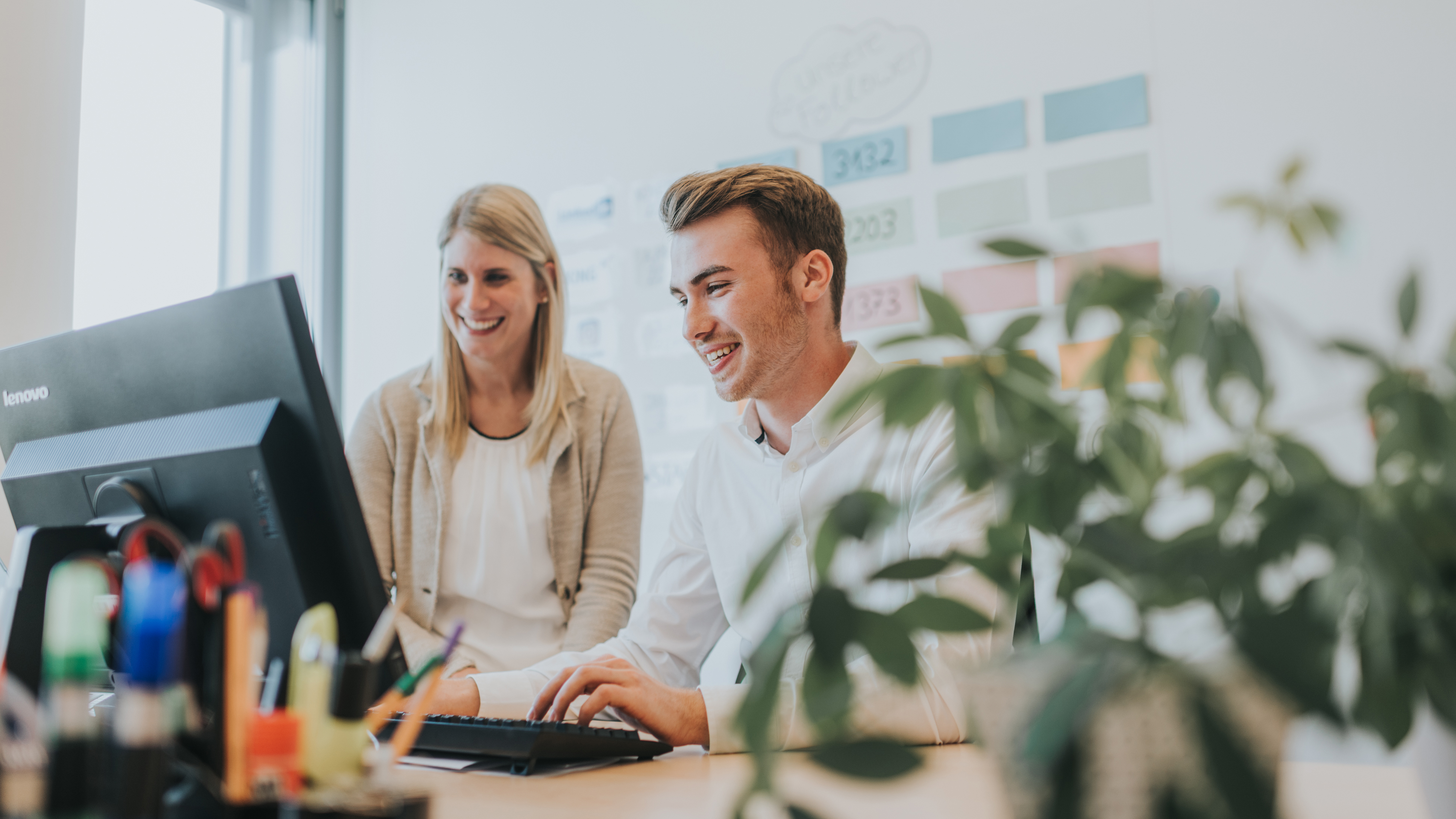 Zwei junge Angestellte arbeiten am Computer