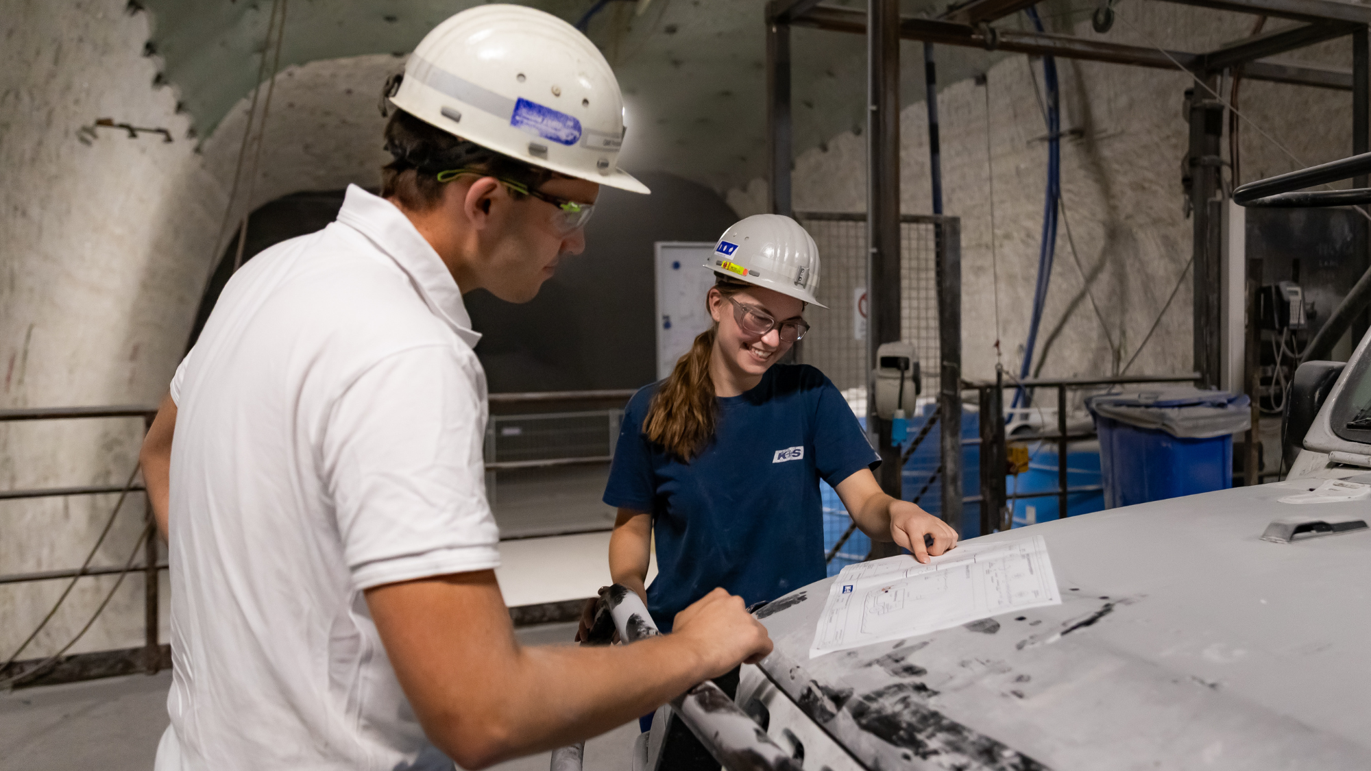 Werkstudentin prüft technische Pläne unter Tage.