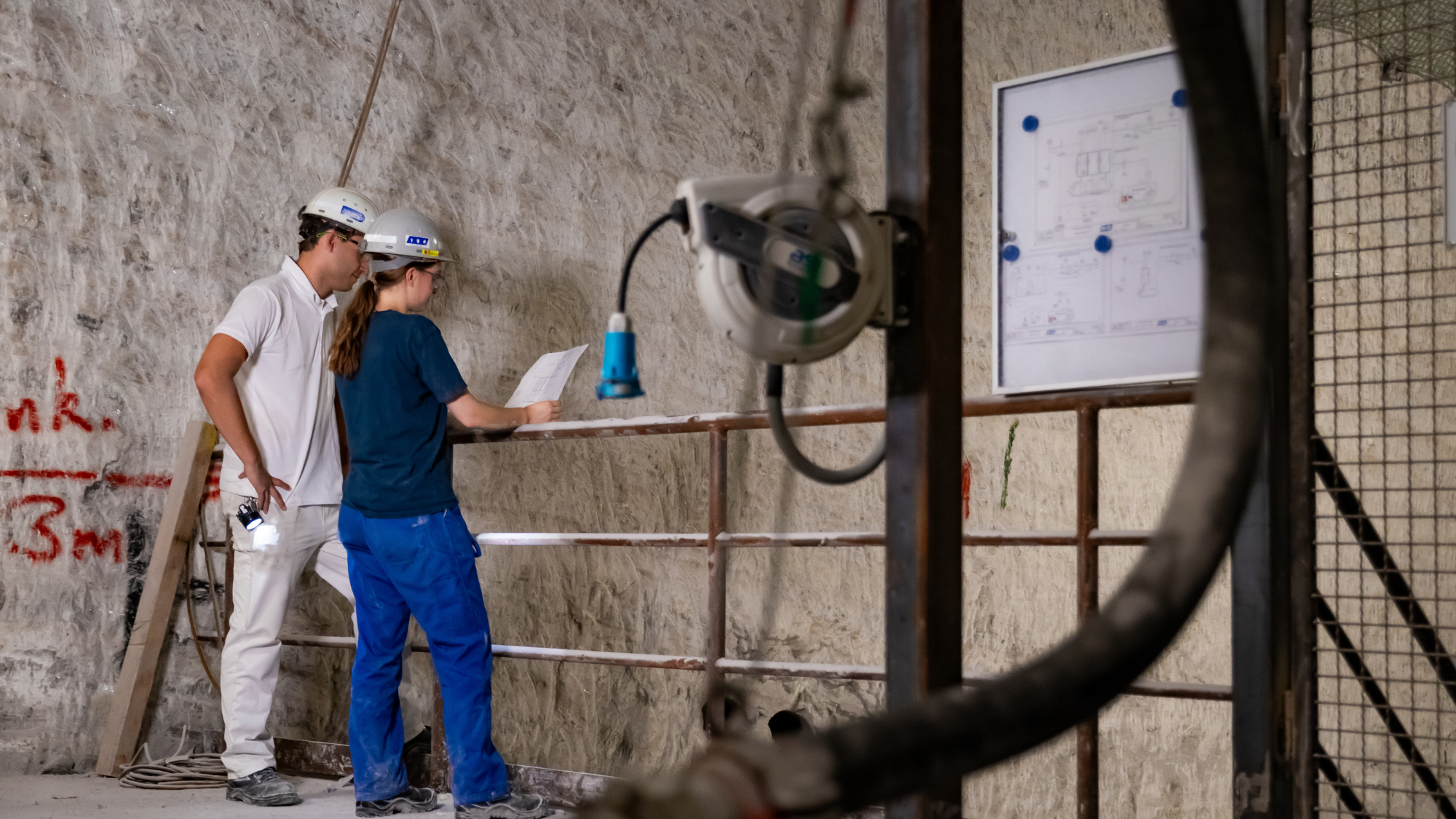 Werkstudentin bespricht technische Pläne unter Tage.