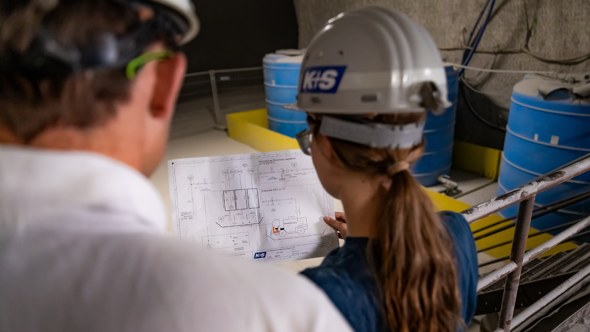 Werkstudentin bespricht technische Pläne unter Tage.
