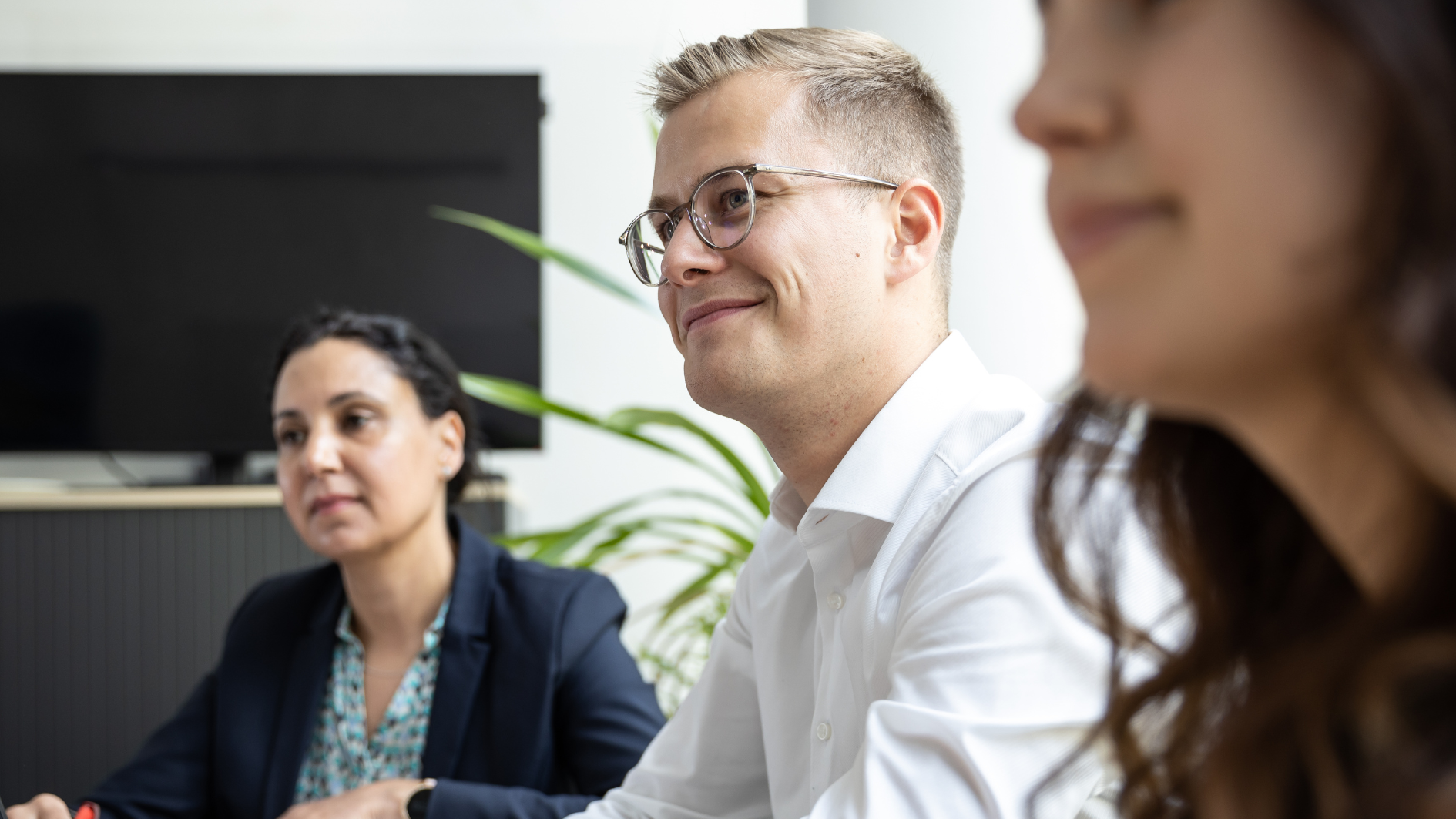 Ein Mitarbeiter lächelt seitlich in die Kamera