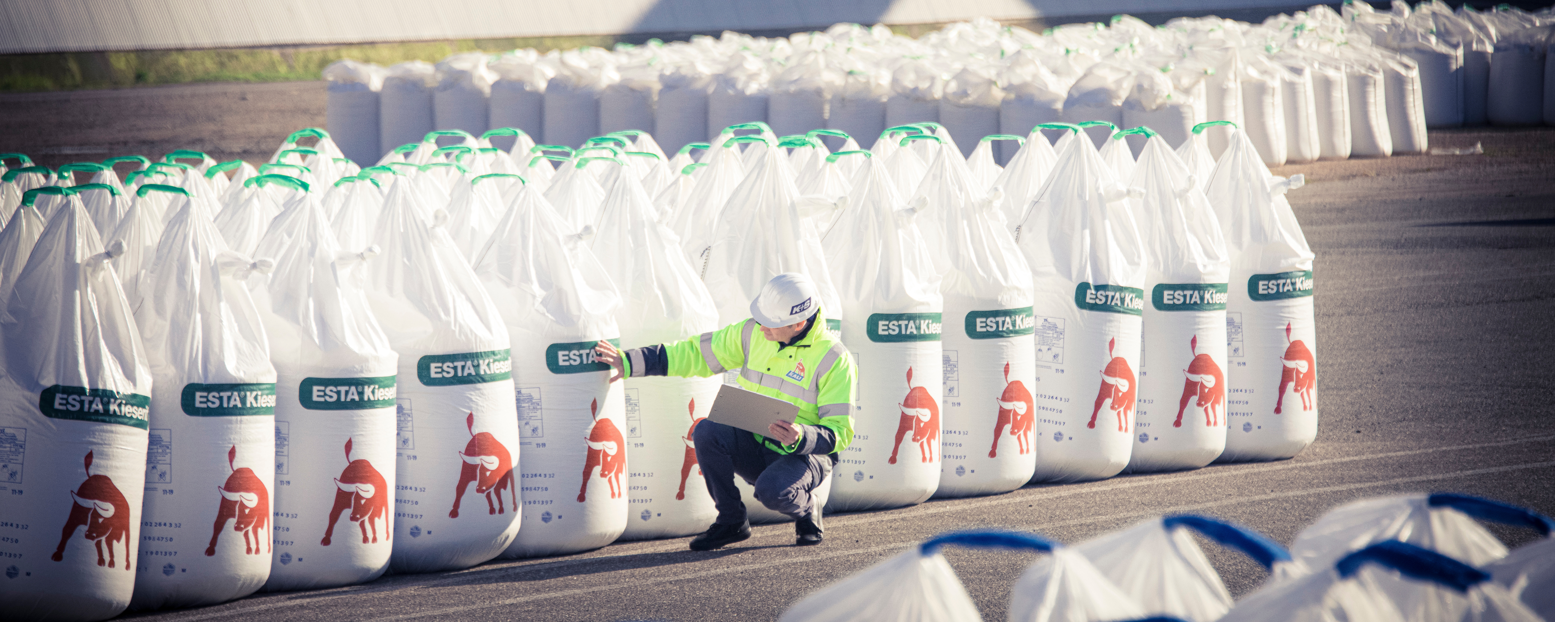 Trainee kontrolliert verpacktes Düngemittel im Werk.