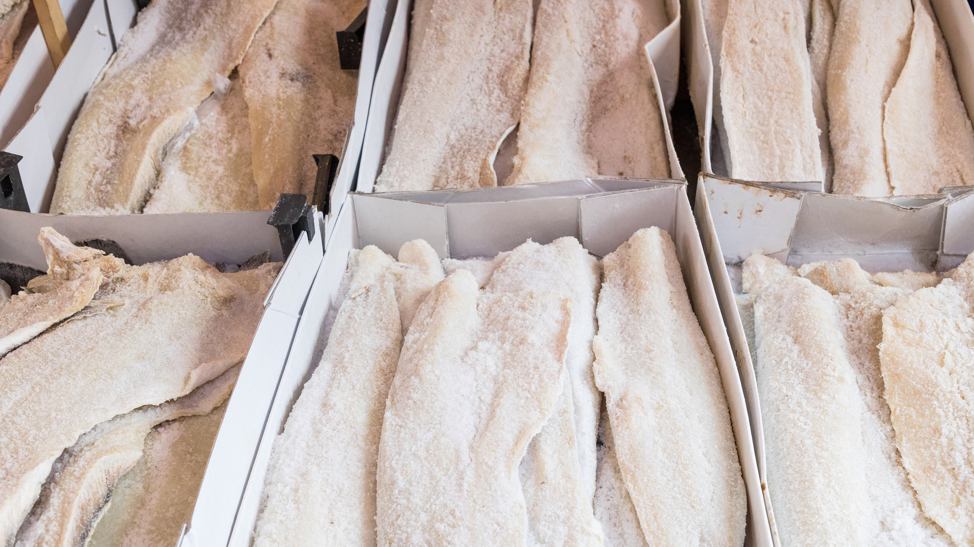 Mehrere mit Salz bedeckte Fischfilets in weissen Kartons