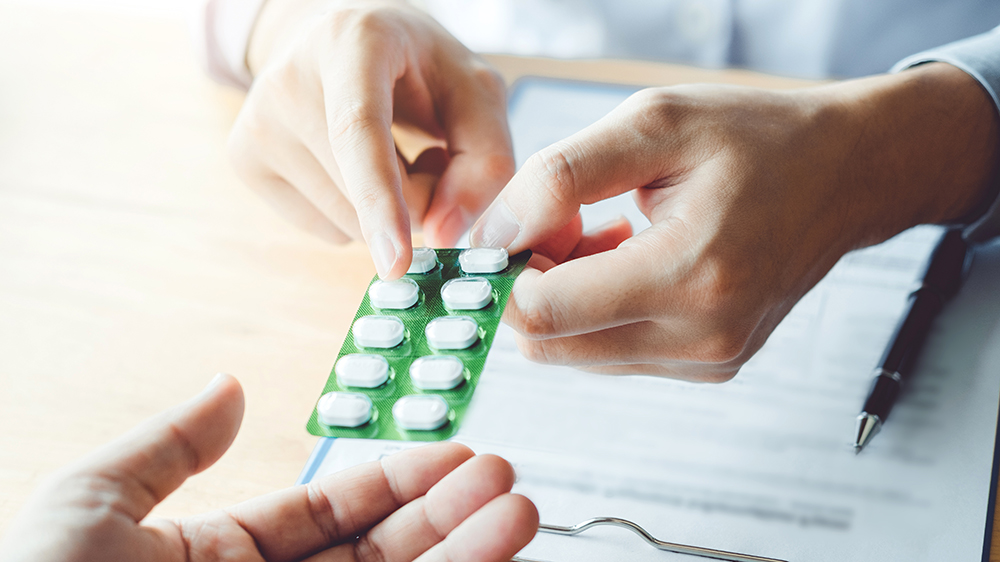 Arzt übergibt einem Patienten Medikamente